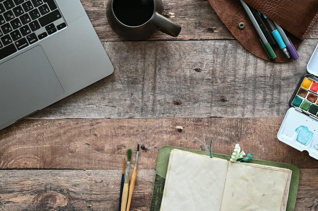 Laptop, Notizbuch und Kaffeetasse auf einem Holztisch – Kosten für UPIPTV durchrechnen