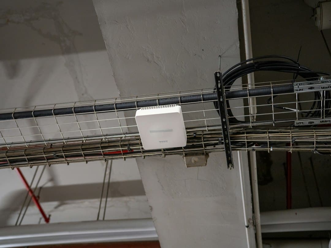 Kabeltrasse mit Netzwerkkabeln und einem WLAN-Access-Point – das Netz hinter der IPTV M3U Playlist von UPIPTV